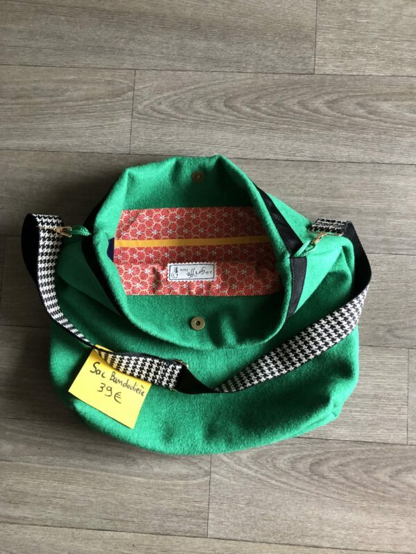 Sac en laine bouillie vert sapin à bandoulière réglable motif pied de poule. Intérieur motifs géométriques rouge orangé et multi poches.